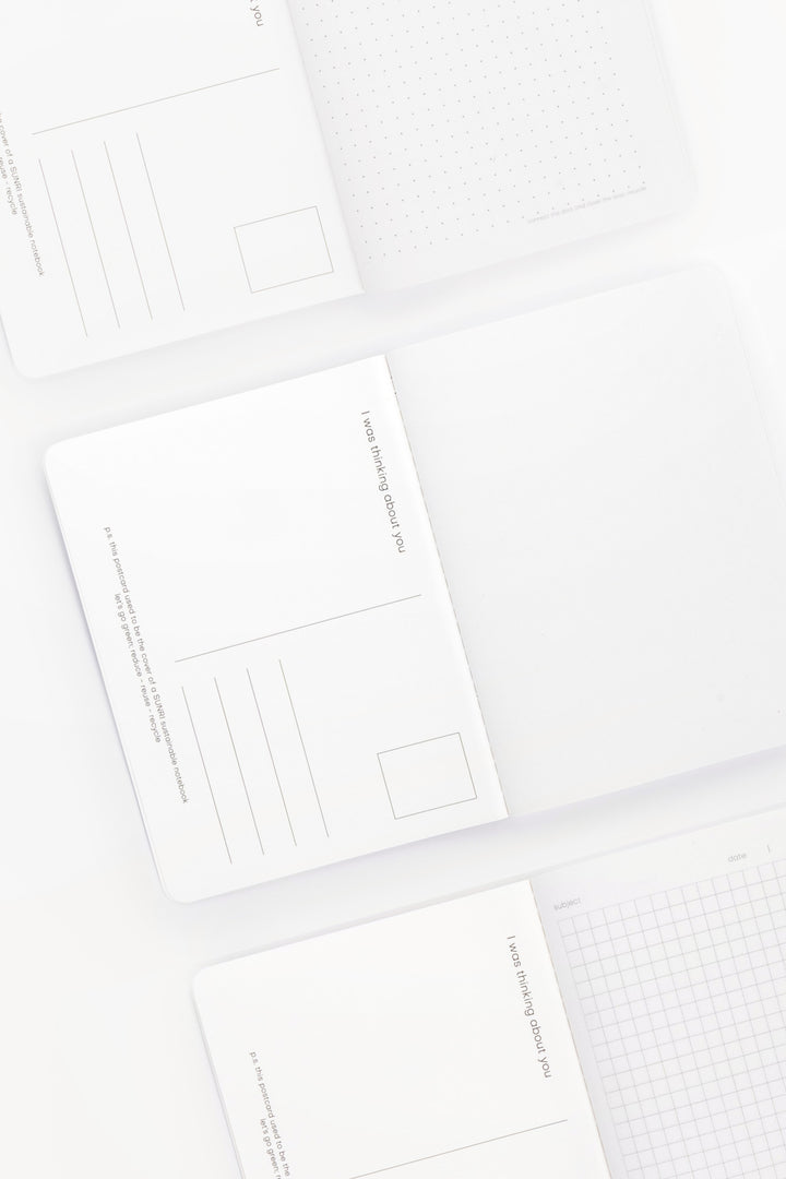 inside of A6 notebooks with different grid patterns and postcard layout on back of cover 