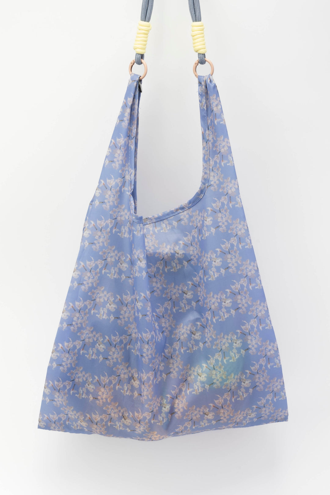 Blue floral-patterned bag with shoulder straps on a white background