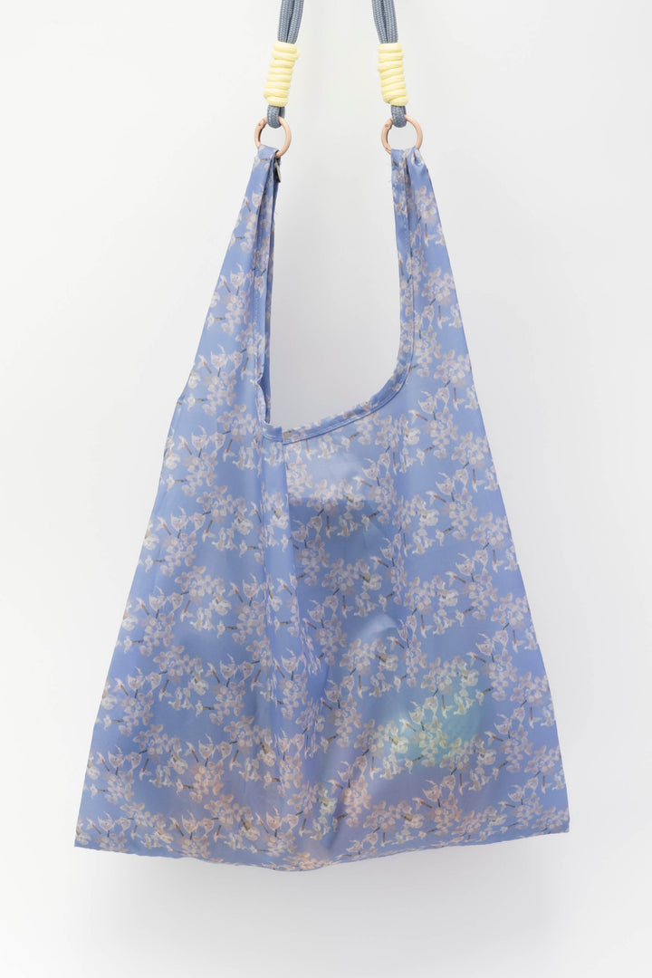 Blue floral-patterned bag with shoulder straps on a white background