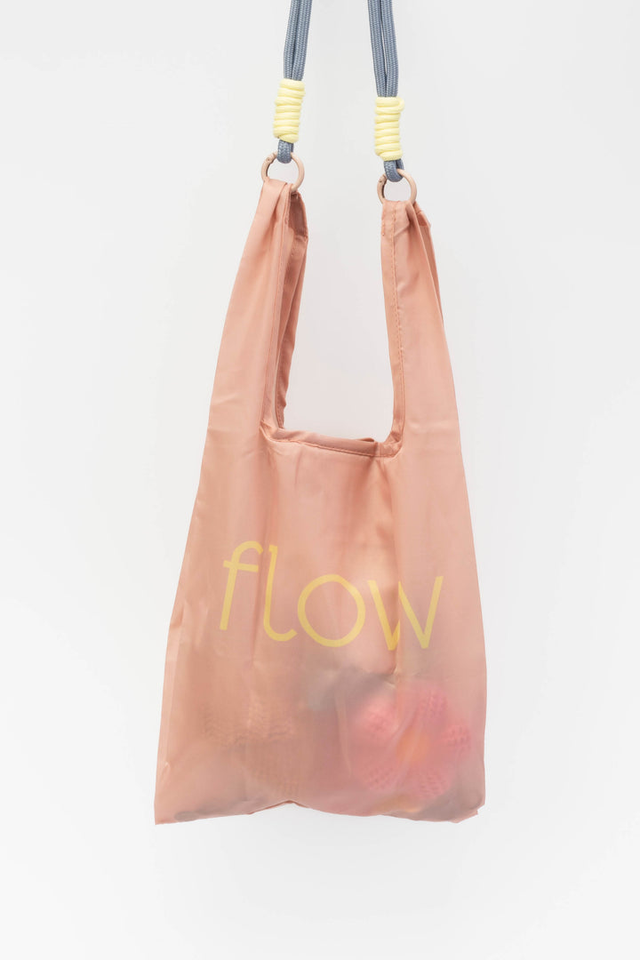 Pink reusable bag with 'flow' text on a white background