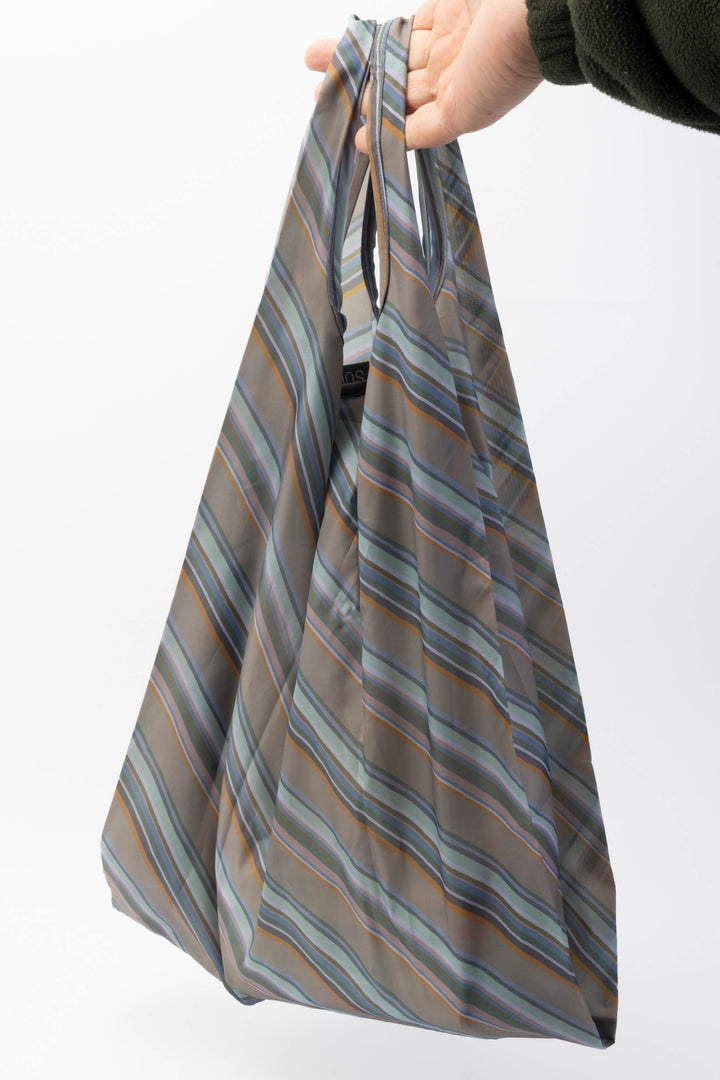 Striped reusable bag held by a hand on a white background
