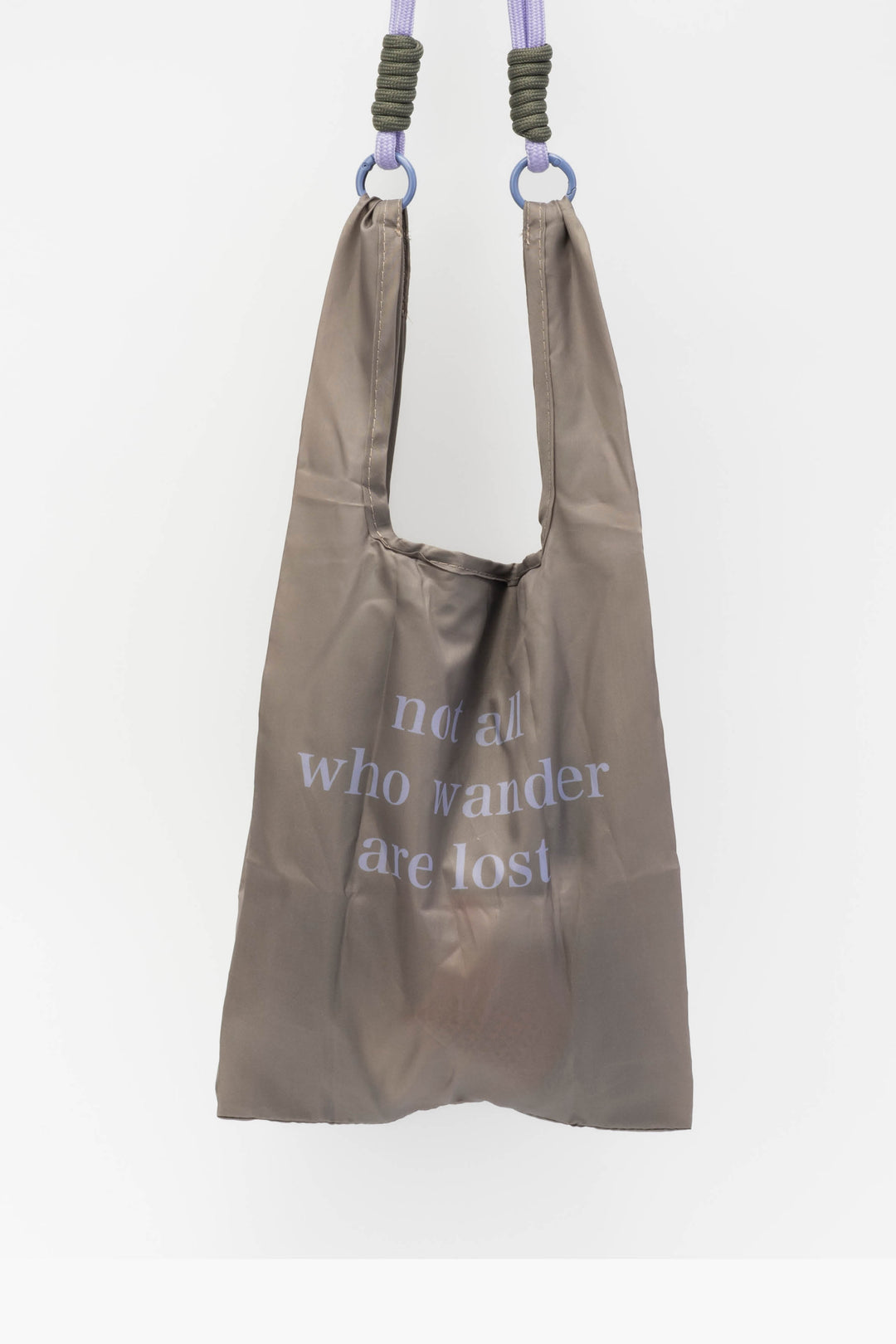 Brown reusable bag with text hanging against a white background