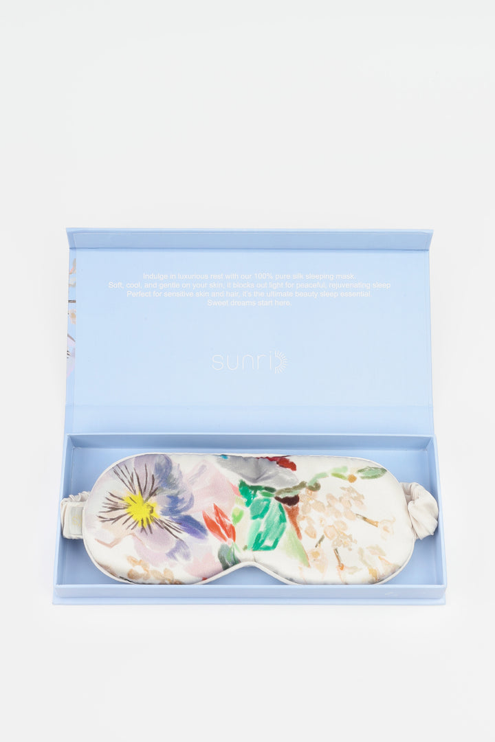 Floral-patterned eye mask in a light blue box on a white background