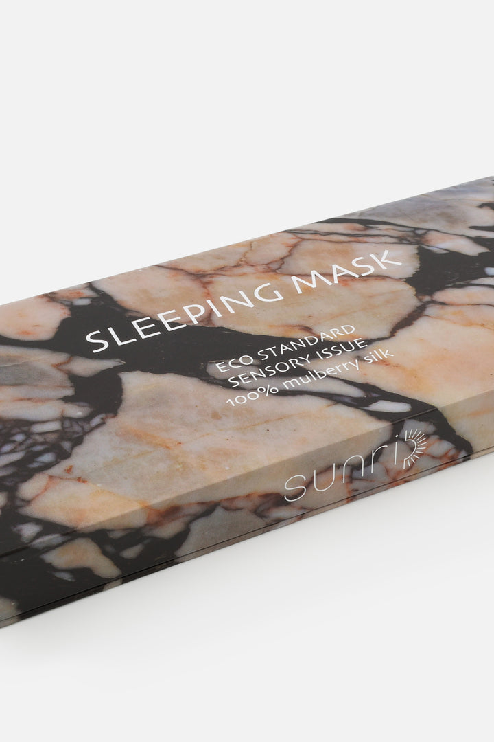 Marble-patterned sleeping mask packaging with text on a white background
