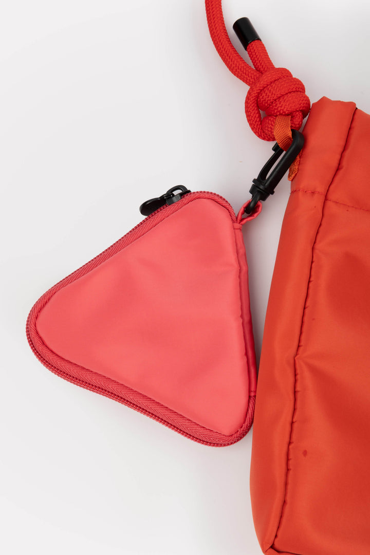 Red pouch with a triangular pocket and rope handle on a white background