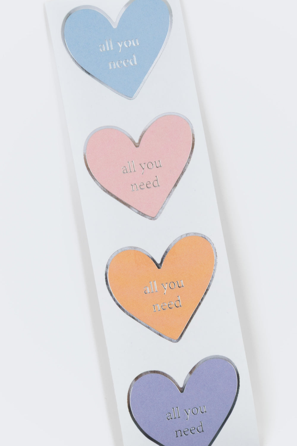 Colorful heart-shaped stickers with motivational phrases on a white background