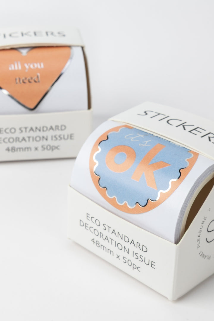 Roll of stickers with 'OK' design on a white background