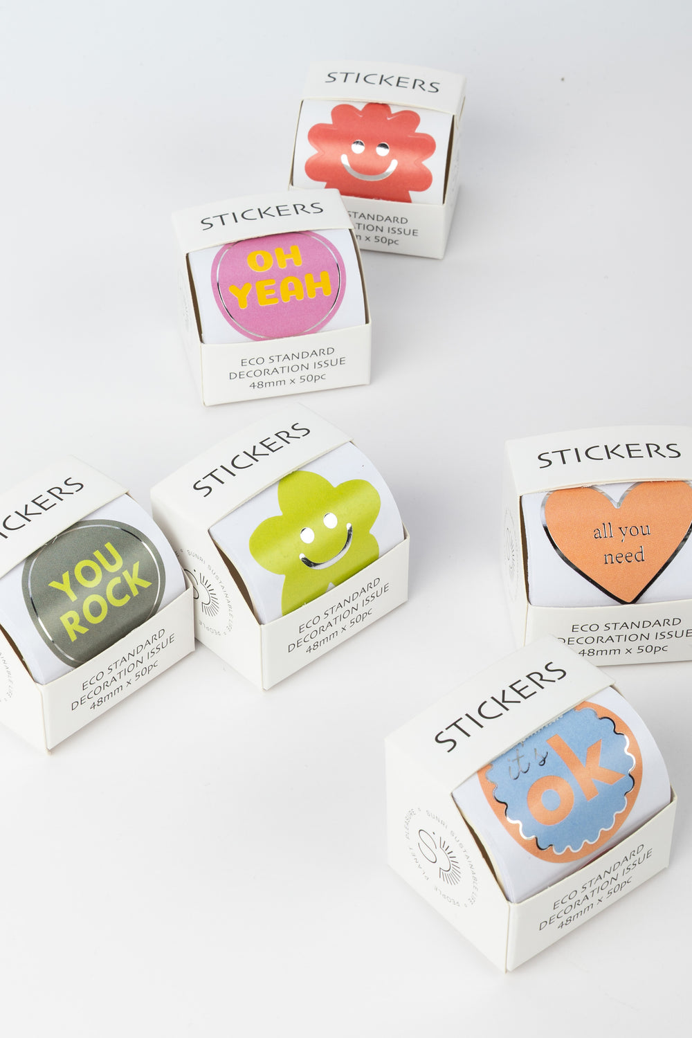 Boxes of stickers with colorful designs and text on a white background