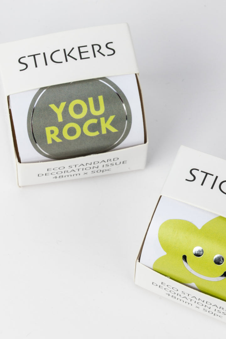 Two boxes of stickers with 'YOU ROCK' and a smiley face design on a white background.