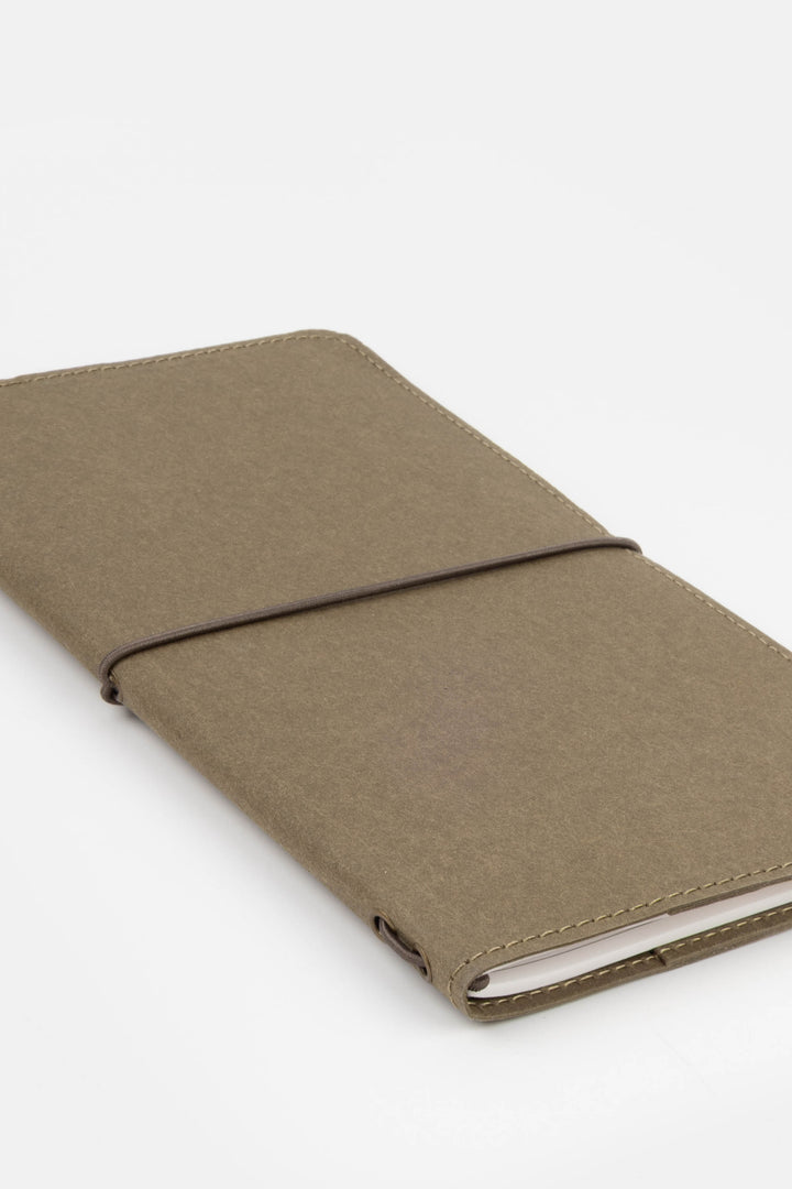 green sketch journal with a strap on a white background