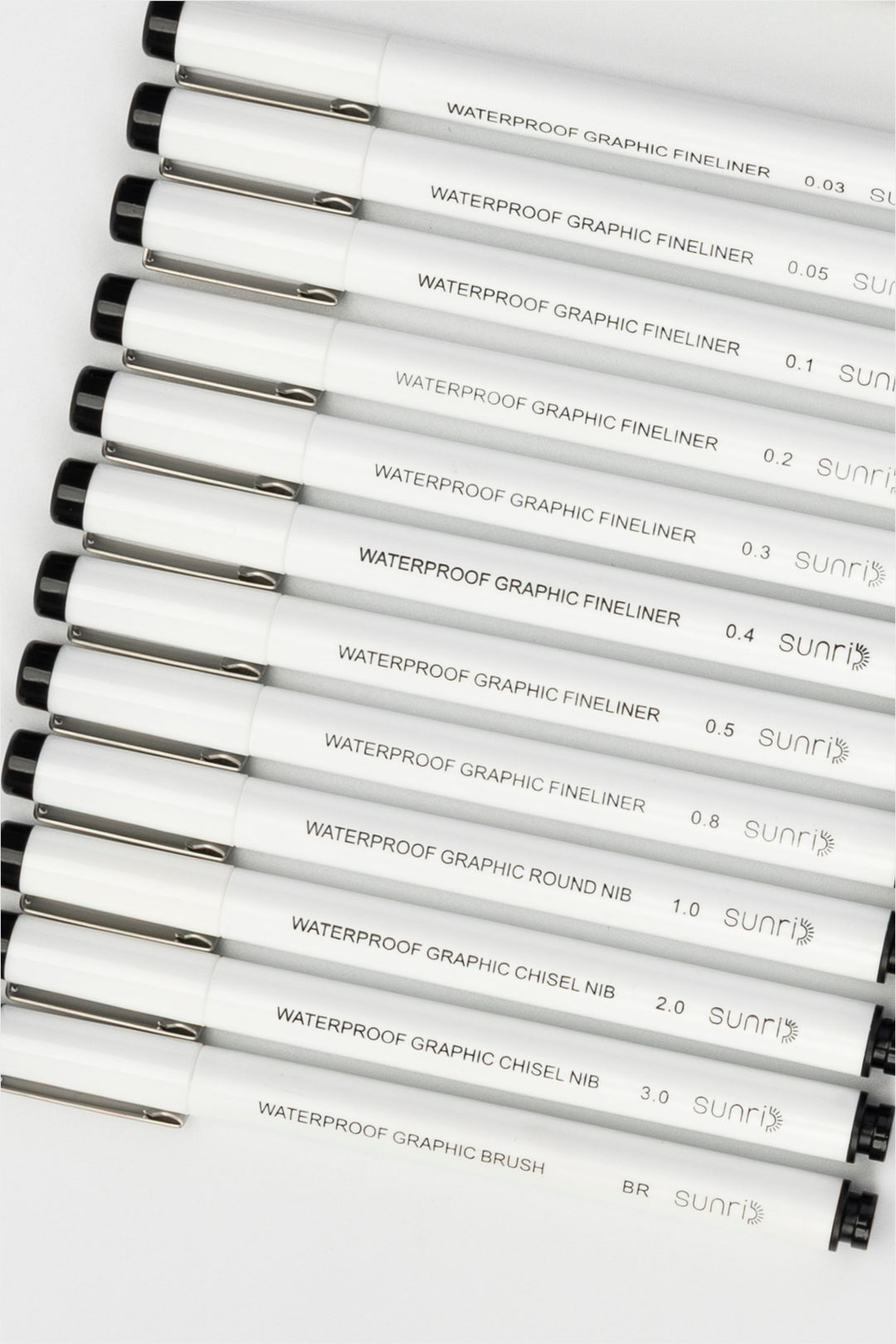 waterproof graphic pens set with multiple white fineliners and brush pen aligned horizontally in different tip sizes
