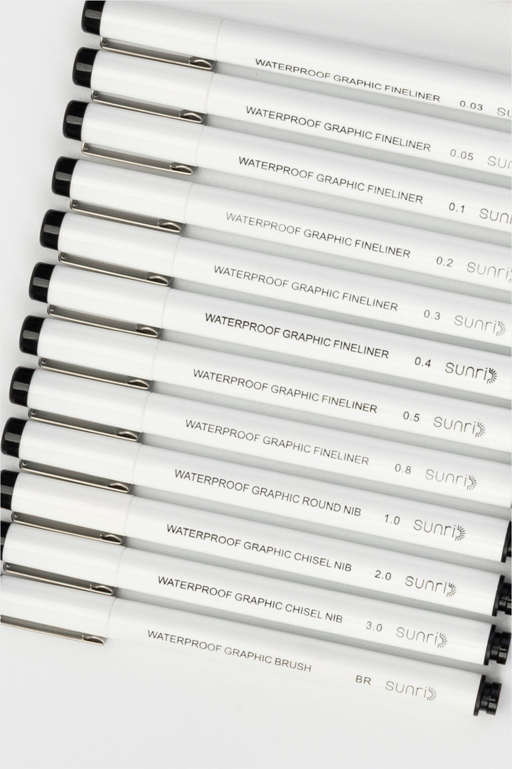 waterproof graphic pens set with multiple white fineliners and brush pen aligned horizontally in different tip sizes
