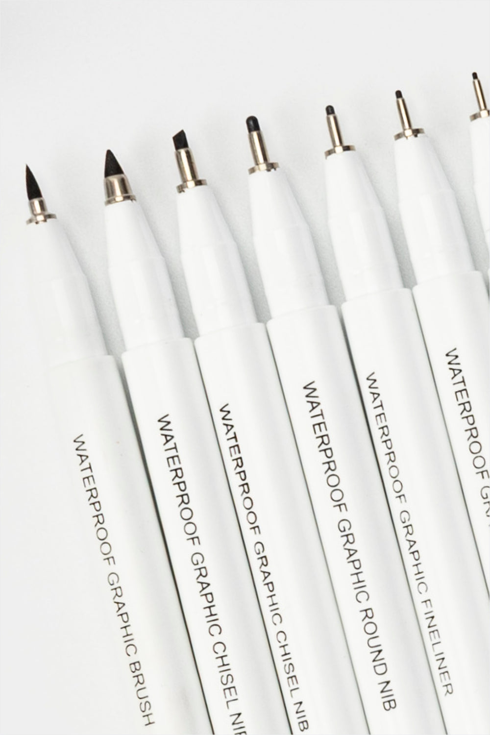 waterproof graphic pens close-up showing different nib shapes including brush, chisel and fineliner tips