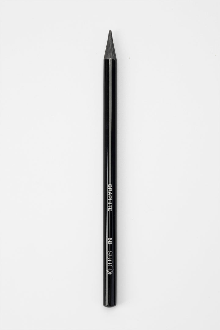 single black woodless graphite sketching pencil upright showing full length and tip
