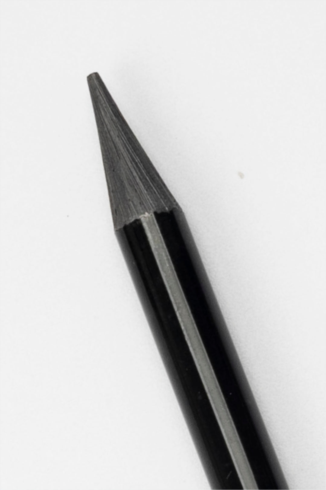 close-up of graphite tip of black woodless sketching pencil showing sharpened point