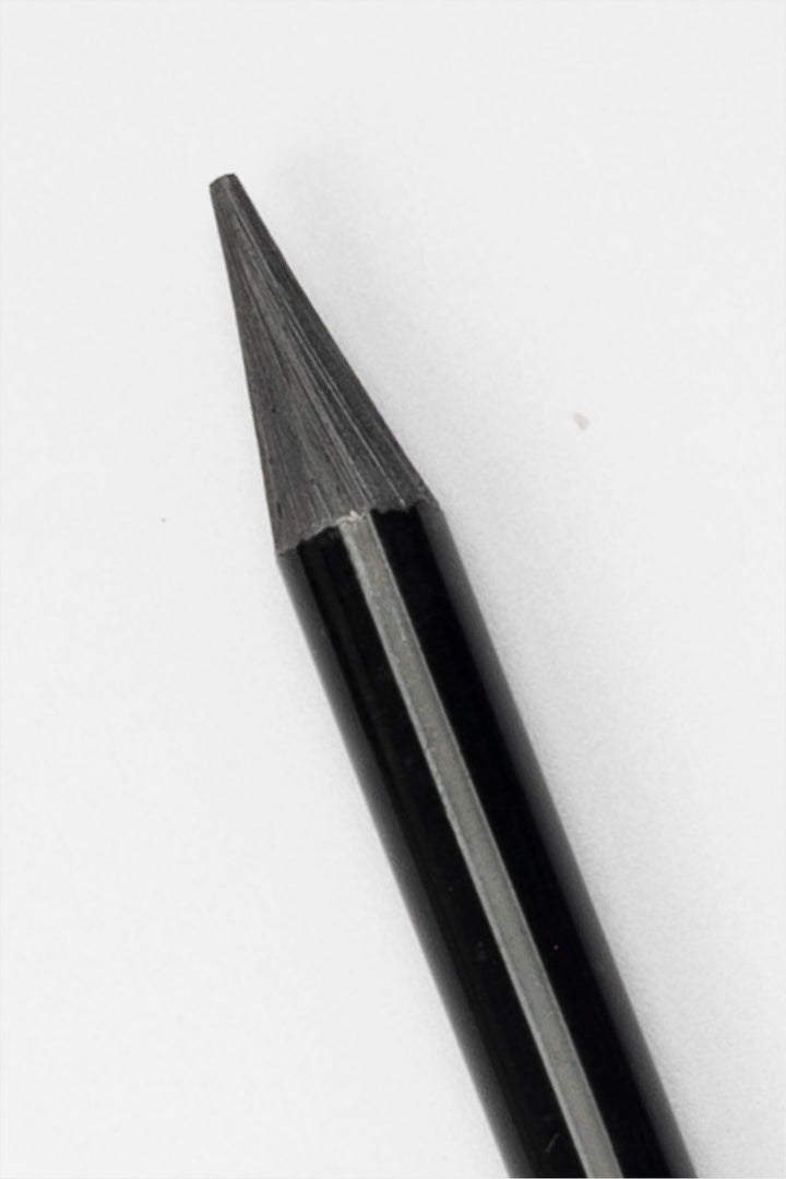 close-up of graphite tip of black woodless sketching pencil showing sharpened point