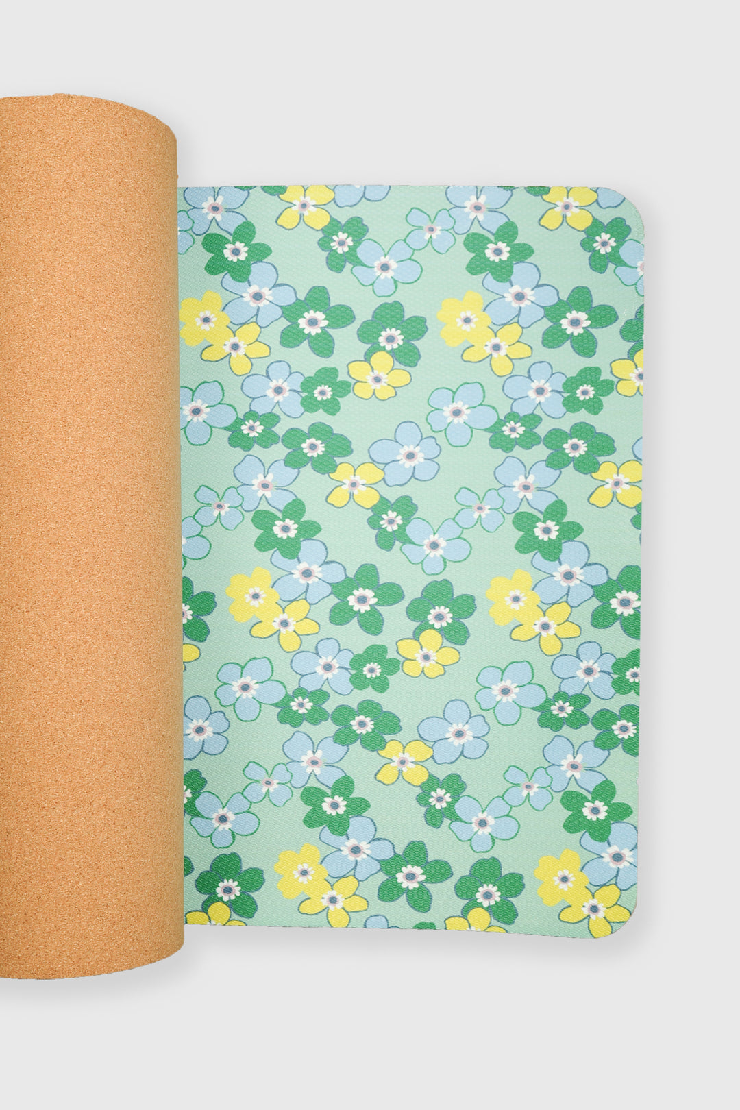 yoga mat half unrolled showing daisy floral surface with cork backing visible
