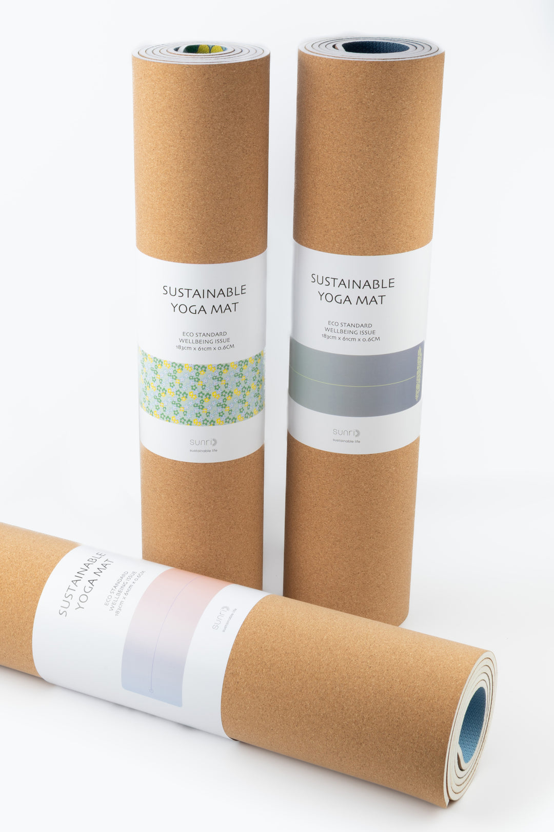 three rolled sustainable yoga mats with cork backing including one with daisy floral belly band
